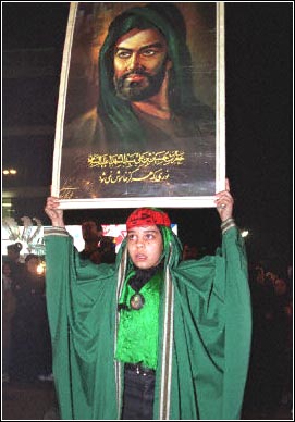 An Iranian boy holds the picture of Imam Ali.